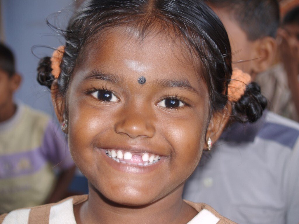Junges Mädchen aus Bangladesh lächelt in Kamera.