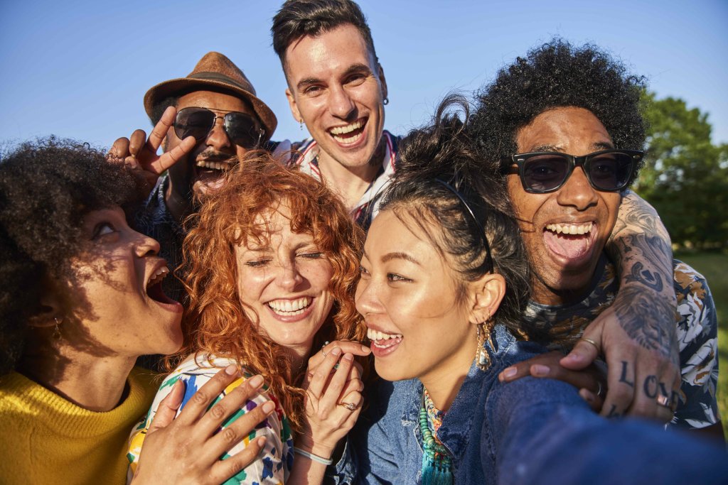 Gruppe von Menschen, die lachen und sich in den Armen halten.